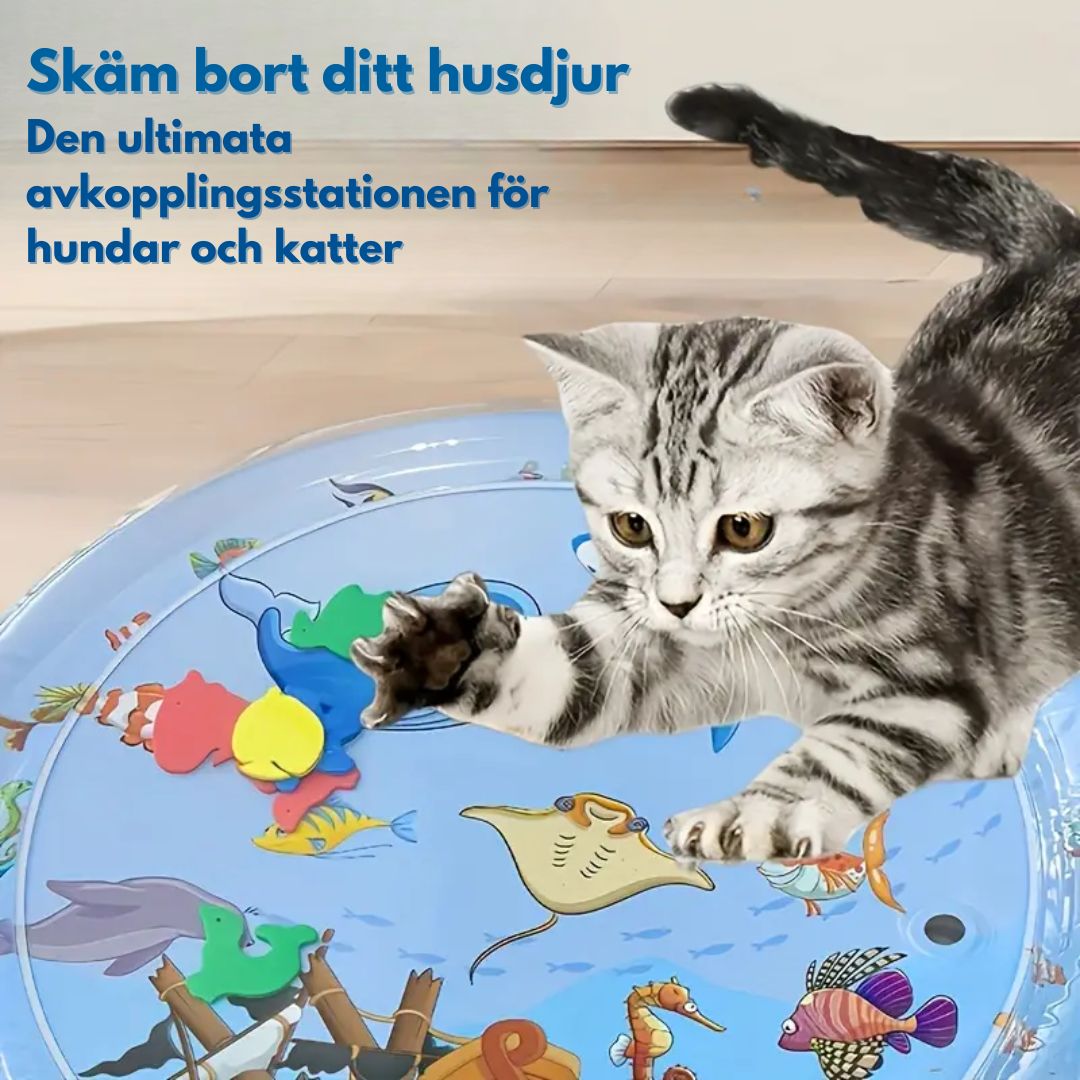 En grå katt leker i en blå vattenleksak med färgglada fiskar och havsdjur. Texten "Skäm bort ditt husdjur Den ultimata avkopplingsstationen för hundar och katter" finns i bilden.